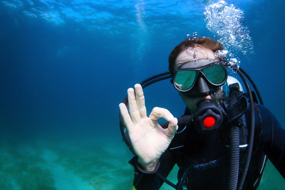 Diver underwater showing the OK sign