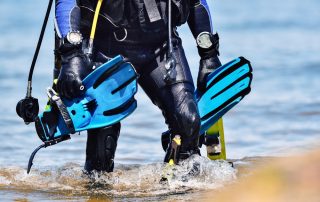 scuba diver walking with gear and dive accessories